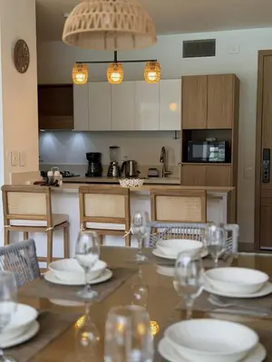 a kitchen with a table with plates and wine glasses at Comfort and Lagoon View at Baia Kristal Cartagena in Los Arrayanes