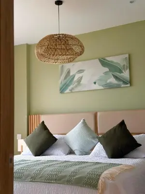 a bedroom with a bed with pillows and a lamp at Comfort and Lagoon View at Baia Kristal Cartagena in Los Arrayanes