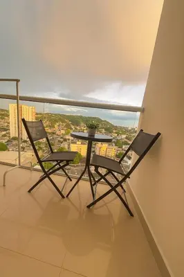 two chairs and a table on a balcony with a view at Oasis Costero Apartment in Cartagena de Indias