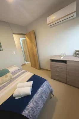 a bedroom with a bed and a dresser with towels at Oasis Costero Apartment in Cartagena de Indias