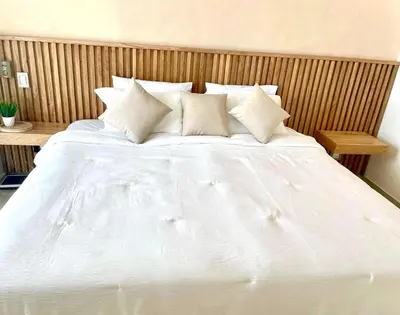 a bed with white sheets and pillows in a bedroom at Luxury apartment sea view with pool- central 12 min from the city center in Cartagena de Indias