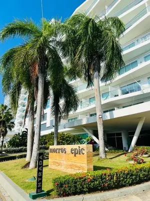 a sign in front of a building with palm trees at Luxury apartment sea view with pool- central 12 min from the city center in Cartagena de Indias