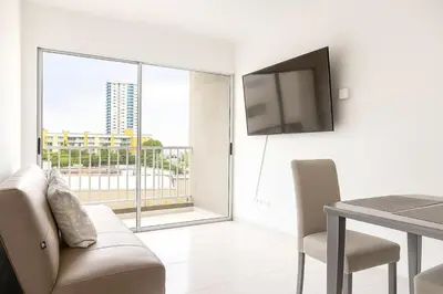 a living room with a television and a table with chairs at VIP Cartagena Close to the 415 Wall in Cartagena de Indias
