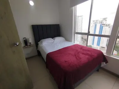 a bedroom with a bed with a red blanket and a window at Cartagena near the historic center and beaches in Cartagena de Indias