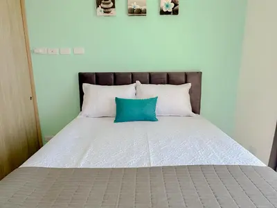 a bed with a blue pillow on top of it at Lujoso apartamento para estrenar Terraz - Playa Dormida in Santa Marta