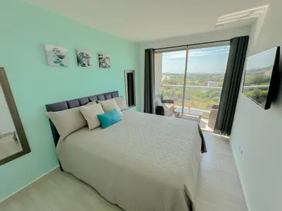 a bedroom with a large bed and a large window at Lujoso apartamento para estrenar Terraz - Playa Dormida in Santa Marta