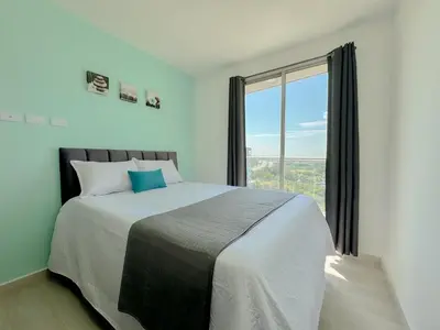 a bedroom with a large bed with a large window at Lujoso apartamento para estrenar Terraz - Playa Dormida in Santa Marta