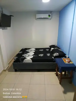 a bedroom with a bed and a table in it at Hospedaje Bosque Mar in Cartagena de Indias
