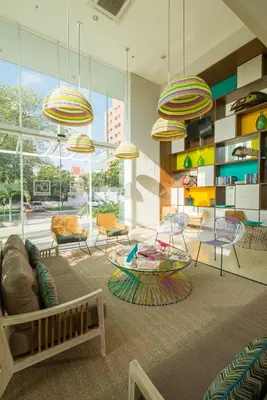 a living room with chairs and tables and large windows at bh Barranquilla in Barranquilla