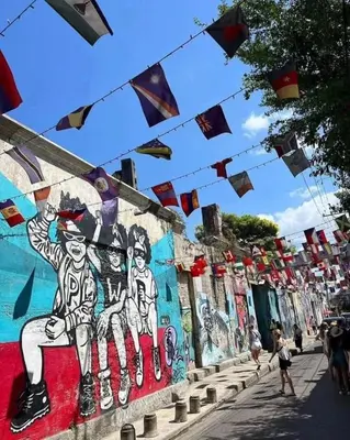 a group of flags hanging over a wall with a mural at Mansión Lujosa con Piscina en manga in Cartagena de Indias