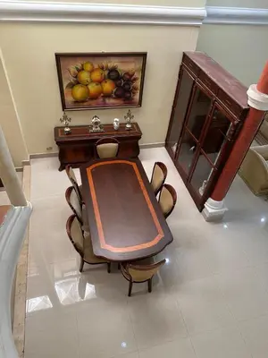 a table and chairs with a painting of fruit on the wall at Mansión Lujosa con Piscina en manga in Cartagena de Indias