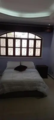a bedroom with a large bed with a large window at Mansión Lujosa con Piscina en manga in Cartagena de Indias