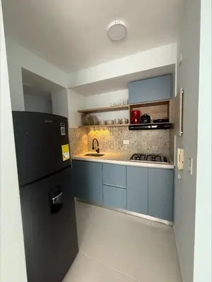 a kitchen with blue cabinets and a black refrigerator at Piso Don Omar in Cartagena de Indias