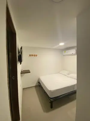 a small white room with a bed in it at HOTEL DIMAR i in Cartagena de Indias