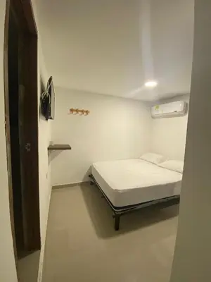 a small white room with a bed in it at HOTEL DIMAR i in Cartagena de Indias