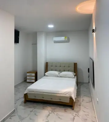 a bedroom with a bed in a white room at Hotel Santa Ana in Baranoa