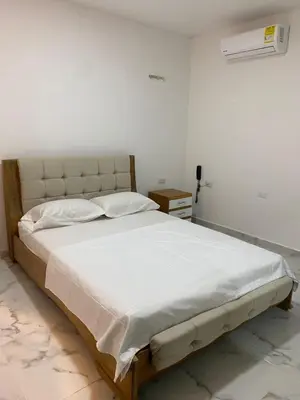 a bedroom with a large bed with white sheets at Hotel Santa Ana in Baranoa