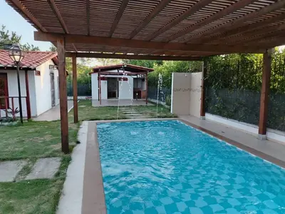 a swimming pool under a wooden pergola at Casa 550 in Turbaco