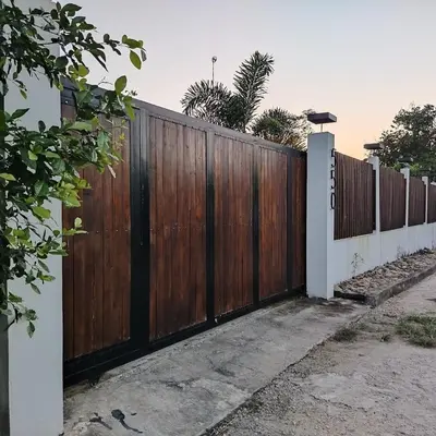 a fence with a wooden gate in a driveway at Casa 550 in Turbaco