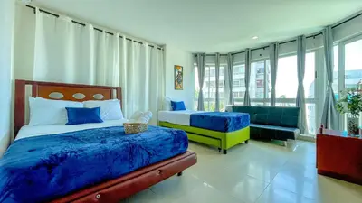 a bedroom with two beds and a couch at Excepcional apartamento Cartagena in Cartagena de Indias
