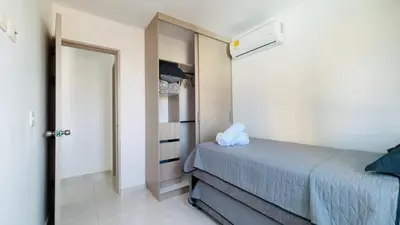a small bedroom with a bed and a closet at Modern Apartment Near the Sea in Cartagena de Indias