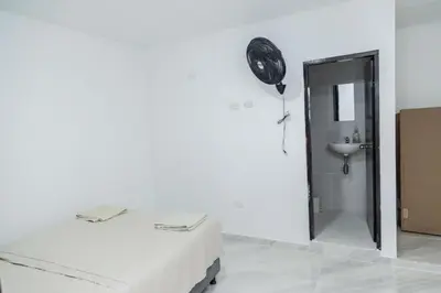 a white room with a bed and a mirror at Apartamentos King Arthur in Punta Seca