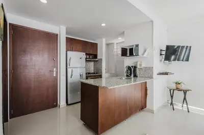 a kitchen with wooden cabinets and a refrigerator at Morros Flamingo Suite - con vista al mar y acceso a la playa in Cartagena de Indias