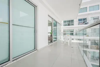 a white hallway with glass windows and a table at Morros Flamingo Suite - con vista al mar y acceso a la playa in Cartagena de Indias