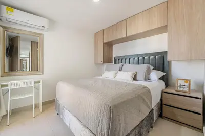 a bedroom with a large bed and a desk at Very close to the beach and the historic center in Cartagena de Indias