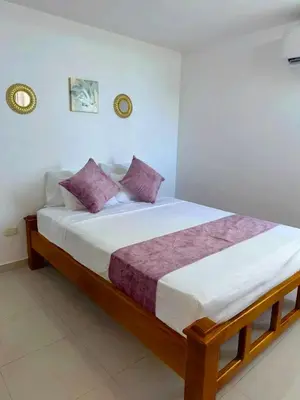 a bedroom with a large bed with purple pillows at Palo Rosa Caribe 202 in Coveñas