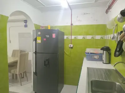 a small kitchen with a refrigerator and a table at shanty guest hostal in Cartagena de Indias