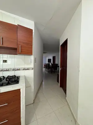 a kitchen with wooden cabinets and a hallway with a table at Cabaña la fortuna in Turbaco