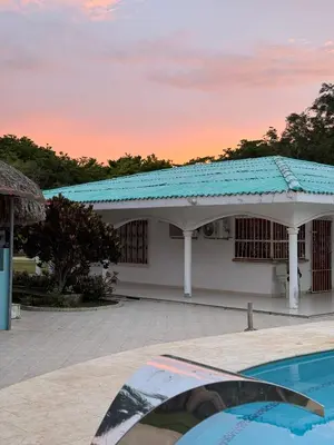 a house with a blue roof and a swimming pool at Cabaña la fortuna in Turbaco