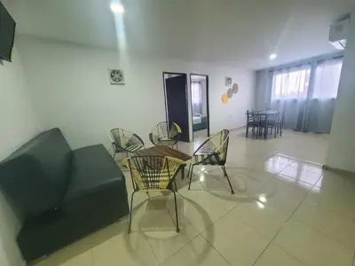 a living room with a table and chairs and a couch at Suite hm caribe in Santa Marta