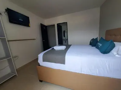 a bedroom with a bed and a tv on the wall at Suite hm caribe in Santa Marta