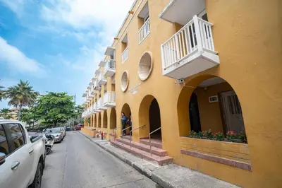 a yellow building with a balcony on a street at San Diego Acogedor Duplex cerca a Bóvedas in Cartagena de Indias