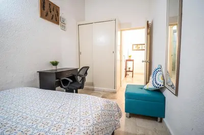 a bedroom with a bed and a desk and a chair at San Diego Acogedor Duplex cerca a Bóvedas in Cartagena de Indias
