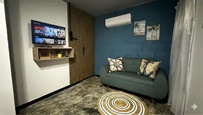 a living room with a couch and a flat screen tv at Cabaña Coveñas Tolú in Coveñas