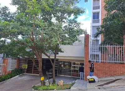 a man standing in front of a building with a tree at APARTAMENTO-Miramar in Barranquilla