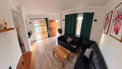 a living room with a black couch and a table at Casa en el lago in Cartagena de Indias