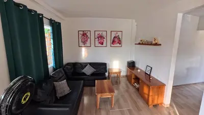 a living room with a black couch and a table at Casa en el lago in Cartagena de Indias