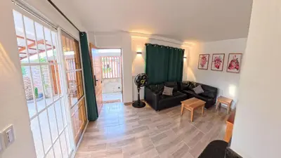 a living room with a black couch and a table at Casa en el lago in Cartagena de Indias