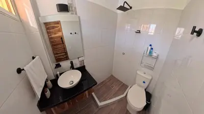 a white bathroom with a toilet and a sink at Casa en el lago in Cartagena de Indias