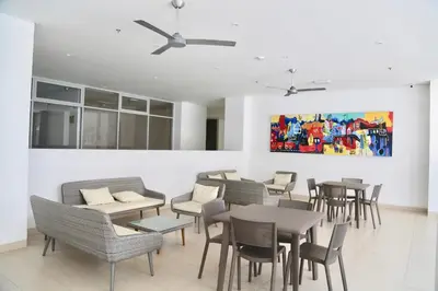a restaurant with tables and chairs and a painting on the wall at Apartamento en Riomar in Barranquilla