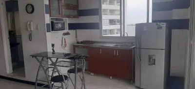 a kitchen with a refrigerator and a table in it at Apartamento Tres Carabelas El Laguito in Cartagena de Indias