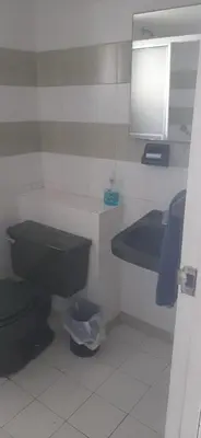 a bathroom with a black toilet and a sink at Apartamento Tres Carabelas El Laguito in Cartagena de Indias