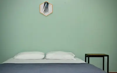 a bed with two pillows and a clock on the wall at Villa frente el mar cartagena de indias in Cartagena de Indias