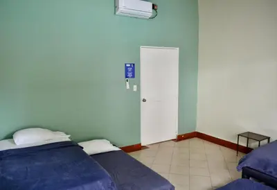 a bedroom with two beds and a white door at Villa frente el mar cartagena de indias in Cartagena de Indias