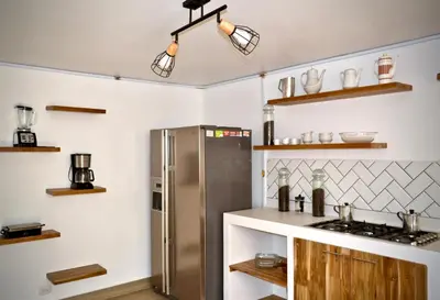 a kitchen with a stainless steel refrigerator and shelves at Villa frente el mar cartagena de indias in Cartagena de Indias