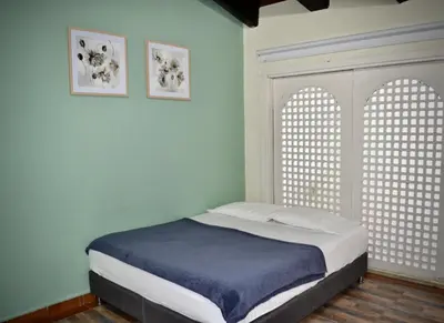 a bed in a room with two arched windows at Villa frente el mar cartagena de indias in Cartagena de Indias